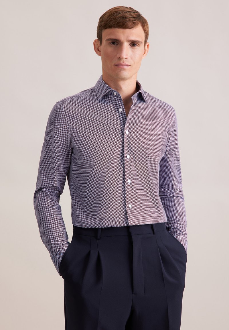 Langarmshirt in een geometrisch patroon in paars en wit, met knoopsluiting en van katoen, gecombineerd met donker op maat gemaakte broeken.