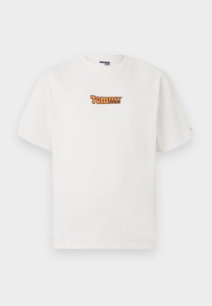 Bela kratka majica s kratkimi rokavi z majhnim oranžnim logotipom "Tommy Jeans" osredotočenim na prsih proti enotni podlagi.