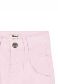 Le pantalon en denim rose présente un bouton frontal avec un emblème d'ours, des passants de ceinture et deux poches latérales avec des détails de couture visibles.