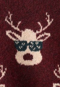 Tessuto lavorato a maglia rosso con un motivo di renna color crema, occhiali da sole neri e corna, che mostra una superficie texturizzata e morbida.