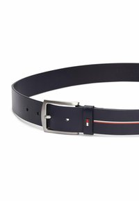 Cintura in pelle blu navy con una fibbia metallica argentata. Presenta un piccolo logo rettangolare in rosso e bianco, e un sottile accento a strisce orizzontali.