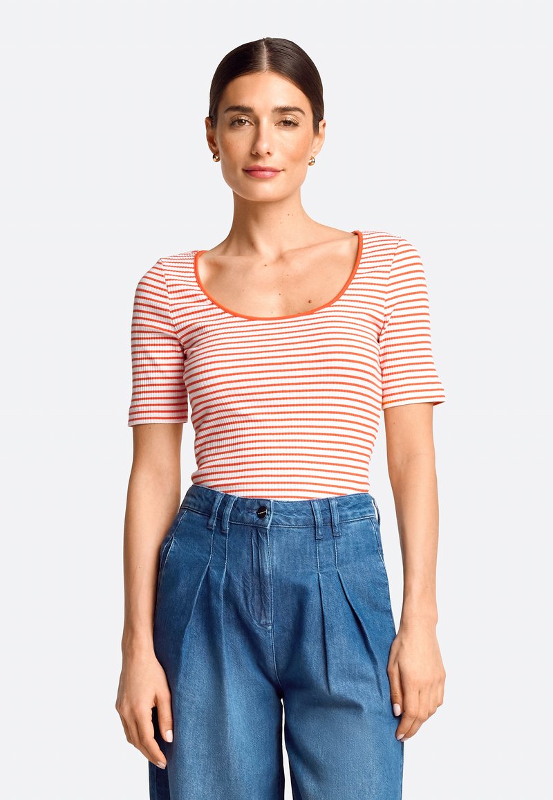 Striped short-sleeve top with a scoop neckline in white and orange, paired with high-waisted denim trousers featuring pleats and a button closure.