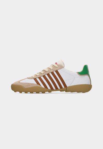 Λευκό sneaker χαμηλού μποτ με καφέ σουέντ ρίγες, μπεζ άκρο από σουέντ, σόλα καουτσούκ και πράσινη ετικέτα στη φτέρνα, σε απλό φόντο.