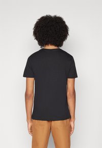 Mustan lyhythihaisen T-paidan, joka on valmistettu pehmeästä puuvillasta, olette crew-neck ja rento istuvuus. Takana on yksinkertainen muotoilu ilman grafiikoita.