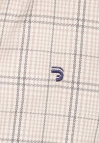 Gecoat stof in lichtbeige, grijs en wit met een zachte textuur; heeft een klein blauw geborduurd logo in de rechteronderhoek.