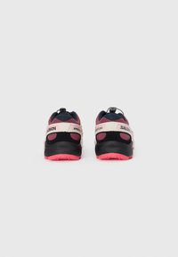 Vue arrière des chaussures Salomon, avec un design noir et rose, tige en mesh, col rembourré et semelle en caoutchouc rose avec un motif texturé.