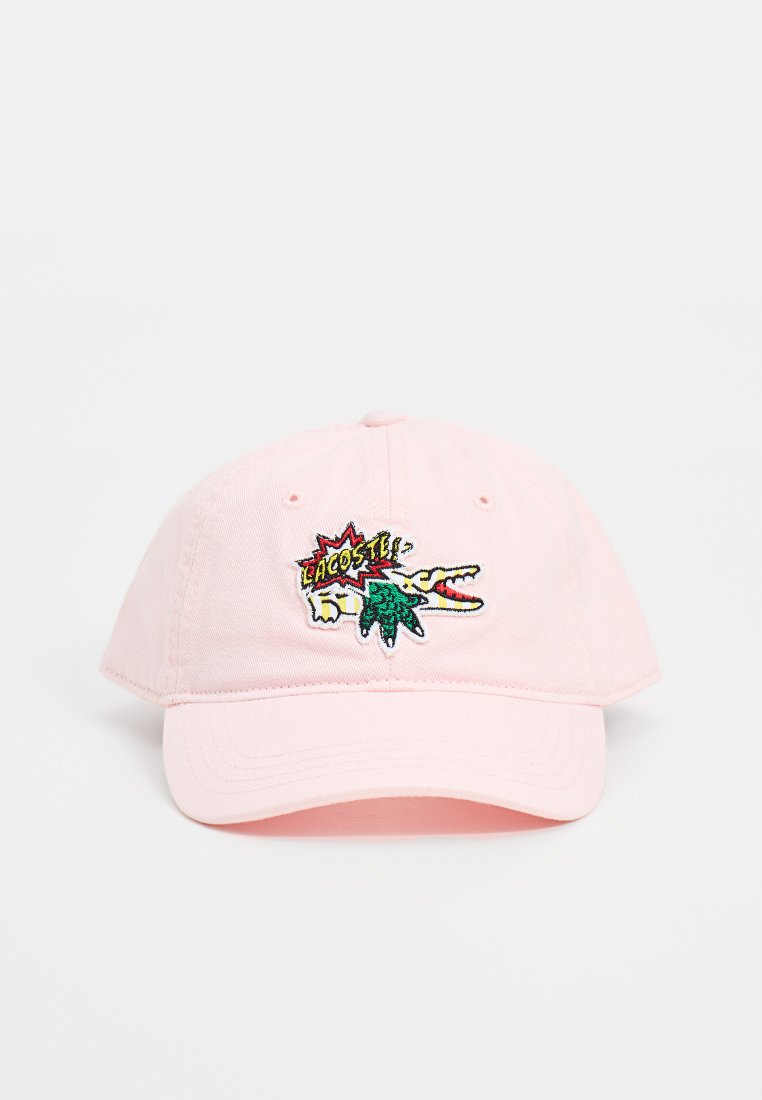Gorra de béisbol de algodón rosa con un logotipo de cocodrilo bordado y el texto "LACOSTE" en colores. Presenta un visera curvada y una correa ajustable.
