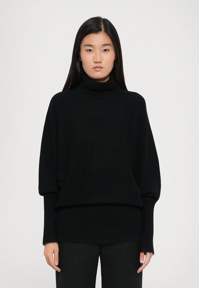Sort turtleneck sweater med løs pasform, ribbede manchetter og nederkanten, lavet af blødt strikket materiale, der har en glat og elegant tekstur.