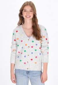 Cárdigan gris claro hecho de un material suave y esponjoso, con acentos en forma de corazones multicolores y botones de madera. Mangas largas con puños acanalados.