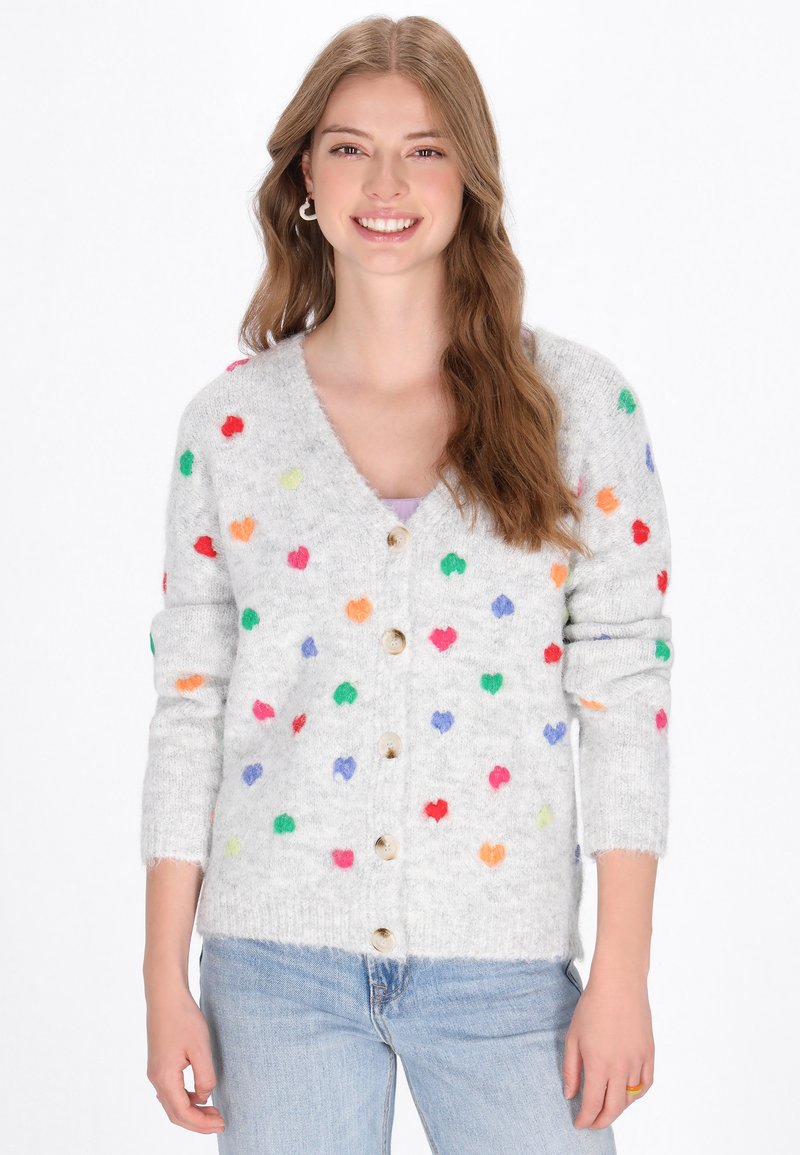 Cárdigan gris claro hecho de un material suave y esponjoso, con acentos en forma de corazones multicolores y botones de madera. Mangas largas con puños acanalados.