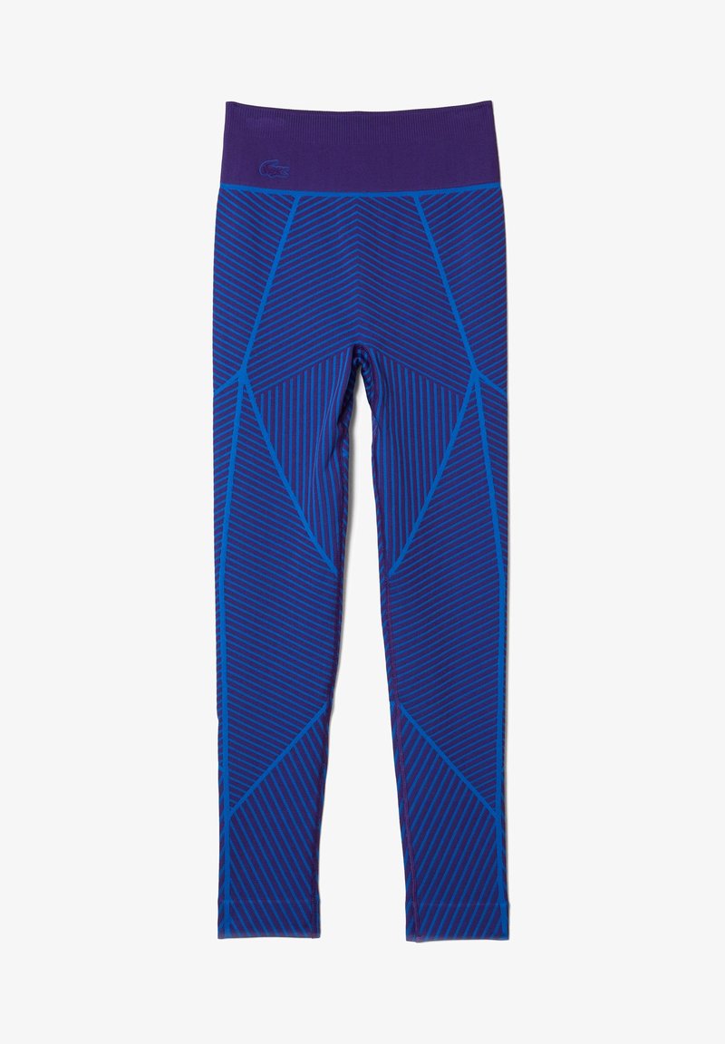 Fioletowe legginsy z geometrycznym wzorem w niebieskim, z ukośnymi paskami. Wykonane z elastycznego materiału, zaprojektowane z myślą o wygodzie i swobodzie ruchów.