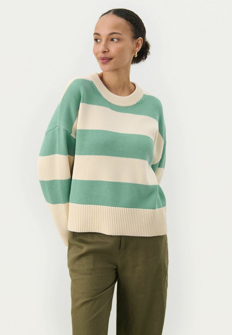 Strikket sweater med brede grønne og beige striber, ribbet rund halsudskæring og sænket skuldre. Sammen med olivengrønne bukser.