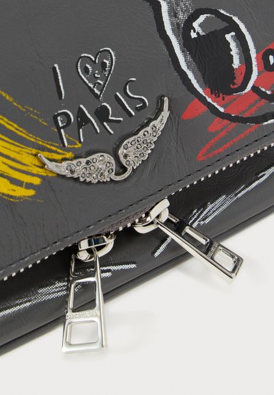 Γκρι τσάντα με ασημένιο καρφίτσα σε σχήμα φτερού, κείμενο «Αγαπώ το Παρίσι» και δύο ασημένια φερμουάρ σε πολύχρωμο γραφικό φόντο.