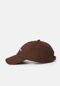 Barna baseball sapka ívelt karimával és állítható pánttal, az elején fehér logóval, sima fehér háttér előtt bemutatva.