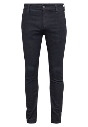 Jean slim noir avec fermeture devant par bouton et zip, passants de ceinture et design cinq poches, présenté sur fond blanc.