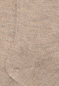 Calzino lavorato a maglia beige con una superficie liscia e tallone rinforzato. Presenta un design classico di lunghezza alla caviglia e un motivo di punto omogeneo.