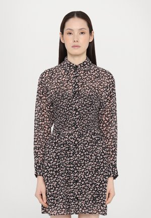 Black floral dress with a collared neckline and long sleeves. Features a smocked bodice and small pink and white floral patterns.