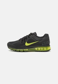Sapatilhas Nike Air Max em malha preta com detalhes em verde brilhante. Apresentam uma sola com amortecimento de ar e painéis texturizados para respirabilidade.