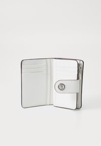 White leather wallet with a snap closure, multiple card slots, and a zippered section. Features contrasting stitching and a metal logo accent.