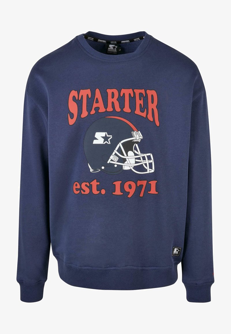 Felpa blu navy con un grande logo rosso "STARTER" e una grafica di casco da football bianco, con "est. 1971" sotto. Tessuto morbido e polsini a costine.
