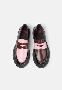 Two-tone shoes with a pink and brown leather upper, featuring a contrasting strap and a thick black sole. Interior branding visible.