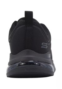 Scarpa sportiva nera con tomaia in tessuto liscio, suola imbottita e parte inferiore lucida nera con branding minimale.