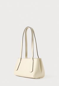 Geantă de mână din piele crem, cu două mânere lungi, formă structurată, textură netedă și bază ușor rotunjită. Accente maro pe margini.