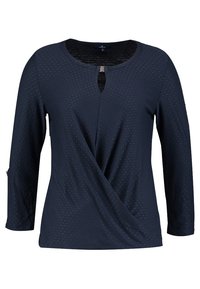 Tummansininen pitkähihainen pusero, jossa on hienovarainen pistekuvio, pyöreä kaula-aukko, etupuolella avaus ja vöille kietoutuva drapointi.