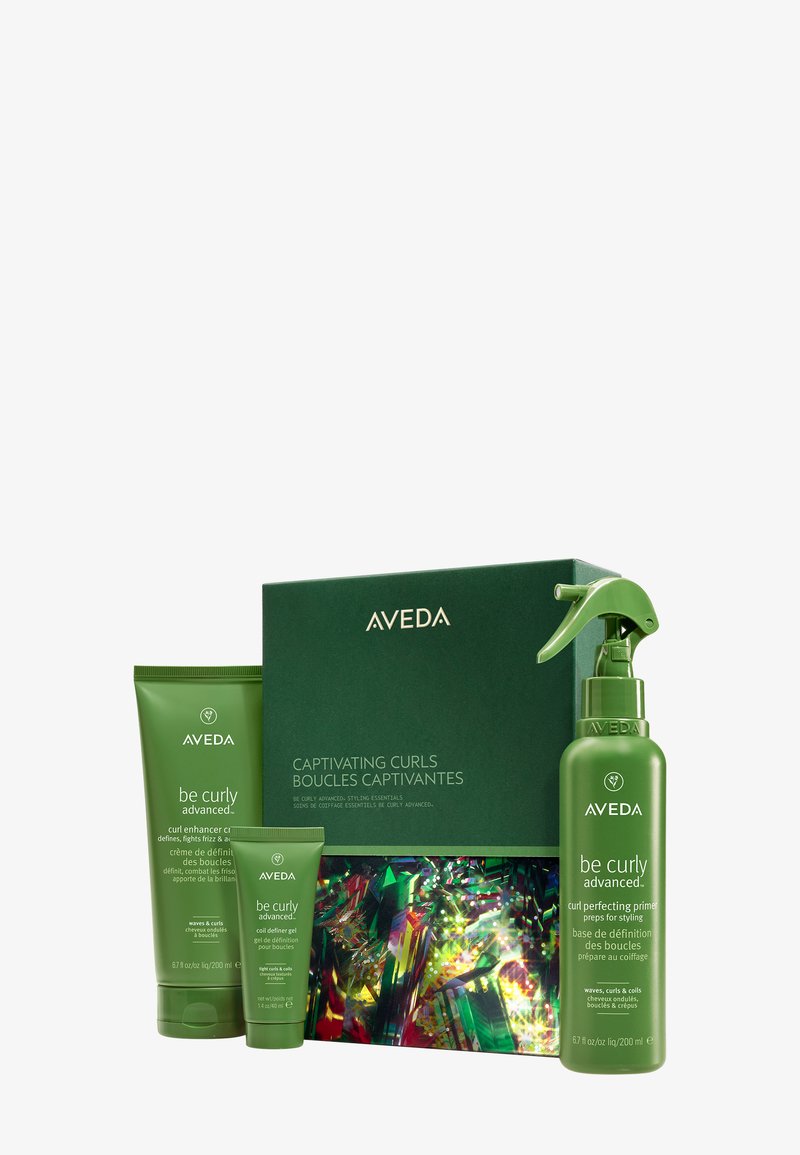 Aveda Be Curly sæt, inkluderer en grøn æske med tre grønne flasker. Produkterne har glatte teksturer, dristige etiketter og en spraydysse på en af flaskerne.