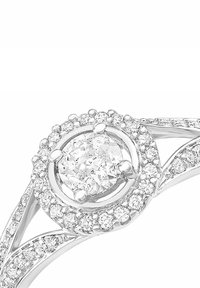 Pierścionek diamentowy w białym złocie, z centralnym okrągłym diamentem otoczonym mniejszymi diamentami w okrągłej koronie, z spiralnym wzorem obrączki.