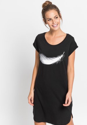 Robe en coton noir avec des manches courtes roulées, présentant un graphique de plume blanche sur la poitrine et des fentes latérales à l'ourlet. Texture douce et coupe décontractée.