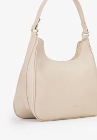 Borsa a tracolla in pelle beige con forma curva, dettagli in metallo dorato e chiusura con cerniera. Texture liscia con dettagli di cucitura sottili.