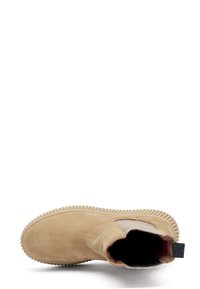 Botín de ante beige con paneles laterales elásticos, suela de goma texturizada y un forro interior suave. Cuenta con una lengüeta en la parte superior para facilitar el calzado.