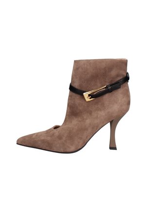 Bottine en daim marron avec un bout pointu, une ouverture sur le devant et une fine sangle noire avec une boucle dorée près de la cheville.