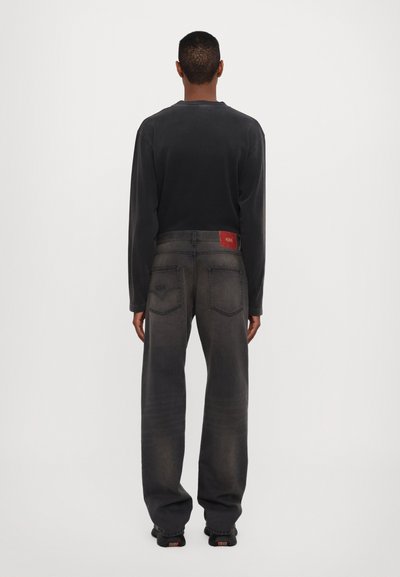 Sive traperice sa opuštenim krojem i izblijedjelom teksturom. Imaju crvenu oznaku na struku i dva stražnja džepa s zakrivljenim šavovima.