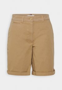 Pantaloni corti in cotone khaki con chiusura a bottone, risvolti piegati e dettaglio della tasca anteriore. Colore uniforme, texture liscia, taglio dritto.