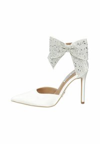White high-heeled shoe with a pointed toe and open side. Features a large, crystal-embellished bow at the ankle. Smooth leather finish.
