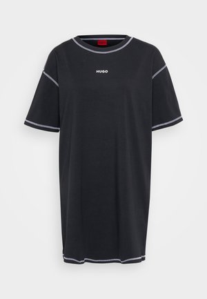 Black T-shirt with white "HUGO" logo, short sleeves, round neck, and contrasting stitch detailing along the edges. Regular fit. Cotton blend material.