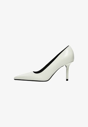 Chaussure à talon haut blanche à bout pointu avec un talon aiguille fin et une doublure intérieure noire sur fond blanc.