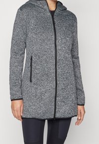 Szary sweter z kapturem, z przednim zamkiem błyskawicznym i dwoma bocznymi kieszeniami na zamek. Posiada teksturowany materiał z ciemnymi akcentami wzdłuż szwów.