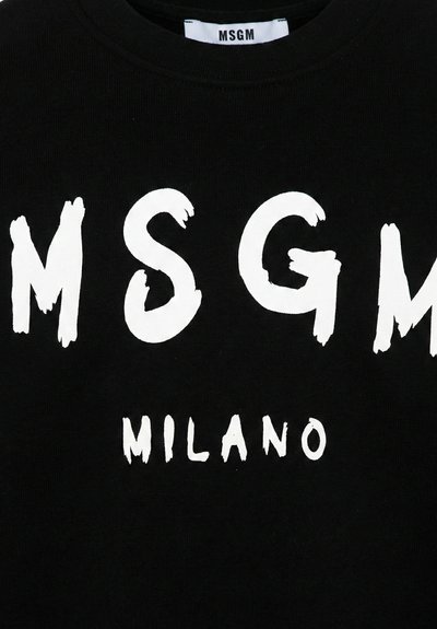 Vêtement noir avec un grand texte blanc "MSGM" et un texte plus petit "MILANO" imprimé en dessous, montrant une étiquette blanche avec "MSGM" à l'intérieur du col.