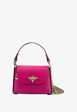 Sac à main en cuir rose avec un emblème d'abeille doré à l'avant, une poignée courte et une bandoulière en chaîne. Présente une bordure contrastante noire.