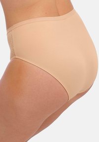 Culotte beige taille haute en tissu lisse, dotée d'un design sans coutures avec une taille en élastique doux et un panneau latéral texturé contrastant.