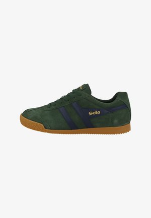 Grüner Wildlederschuh mit marineblauen Streifen, Gummilaufsohle, Schnürdesign und goldenen Logodetails. Klassischer sportlicher Stil.