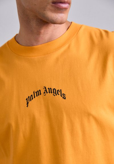 Tricou galben din bumbac cu logo-ul „Palm Angels” în negru, dispus într-un design arcuit. Include un gât rotund și o textură netedă.