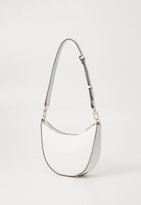 Borsa bianca con silhouette curva, superficie testurizzata, bordi neri e tracolla argentata removibile con hardware regolabile.