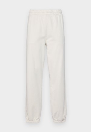 Ανοιχτό μπεζ φόρμες με ελαστική μέση, στενές γάμπες και υφή βουρτσιστού βαμβακιού. Διαθέτει λογότυπο στο μπροστινό μέρος.