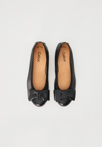 Zwarte leren ballerina's met een ronde neus en een strikaccent. De binnenkant heeft geperforeerde details voor ademend vermogen.