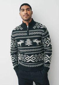 Gestrickter Pullover in Dunkelgrün und Grau, mit Mustern von Elchen und Bäumen, einem hohen Kragen und geometrischen Designs. Gerippte Bündchen und Saum.
