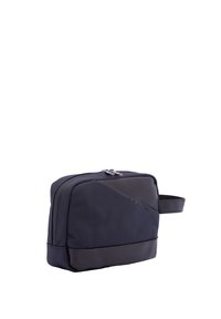 Borsa da toiletta di un blu navy scuro, forma rettangolare, realizzata in tessuto testurizzato con un pannello inferiore liscio, chiusura con zip e una maniglia laterale.